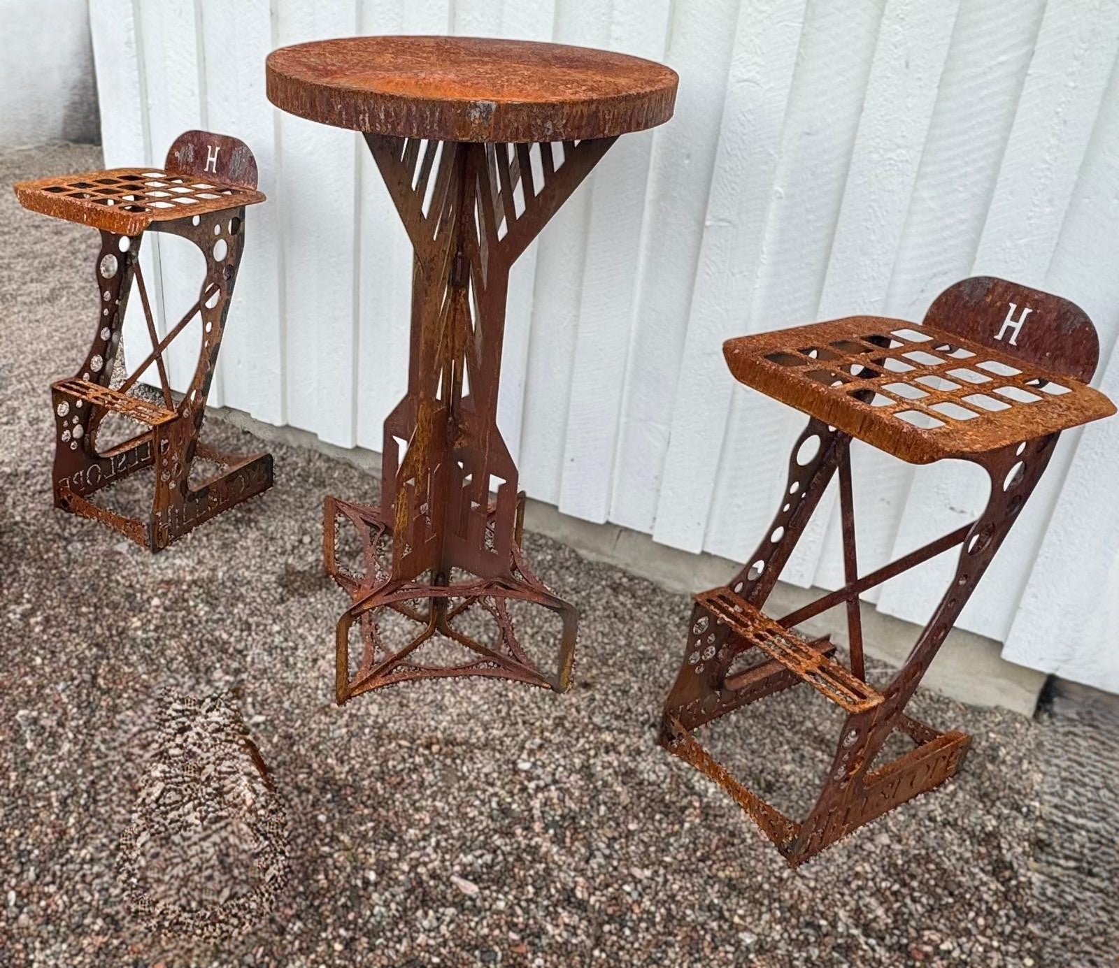 Möbelset av plåt som är utskuren i corten och svetsat samt bockat.