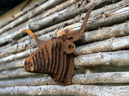 3D-väggkonst Texas Longhorn i rostig corten mot timmervägg